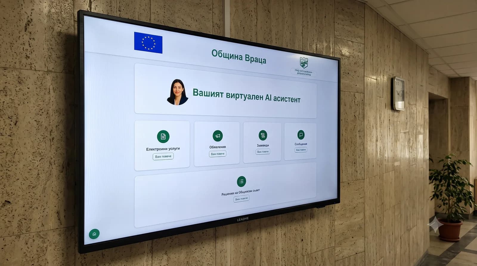 Wall-mounted landscape display showing the Vratsa Municipality board in an administration corridor